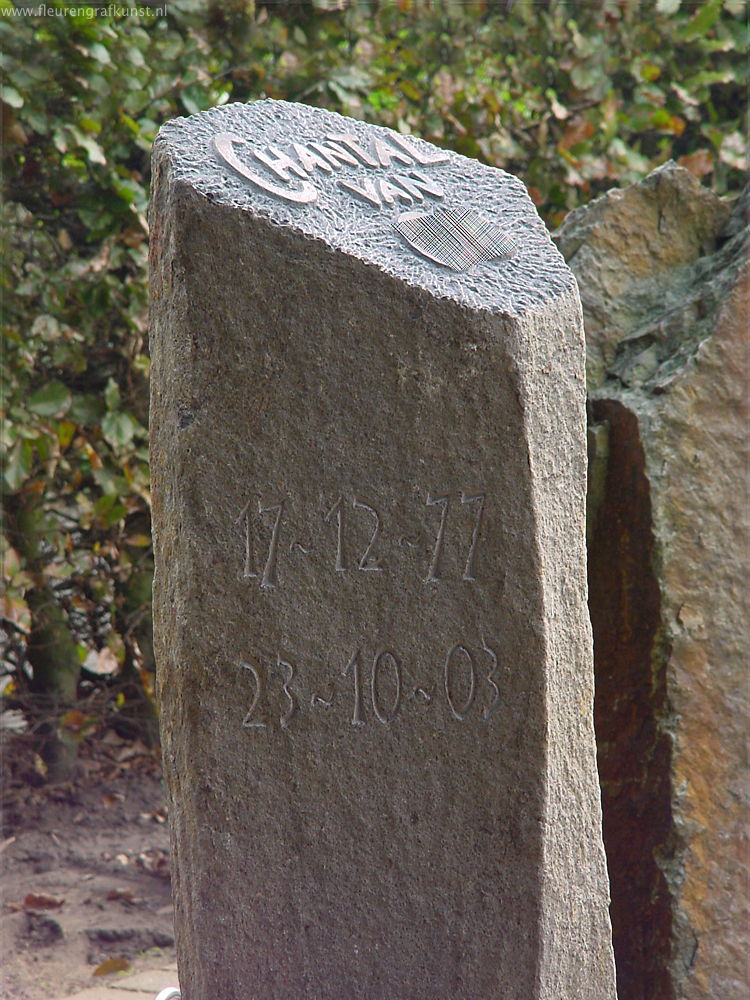 Basalzuil als grafsteen met handgekapte naam en data in reliëf
