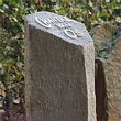 Basaltzuil monument met naam en data in relief