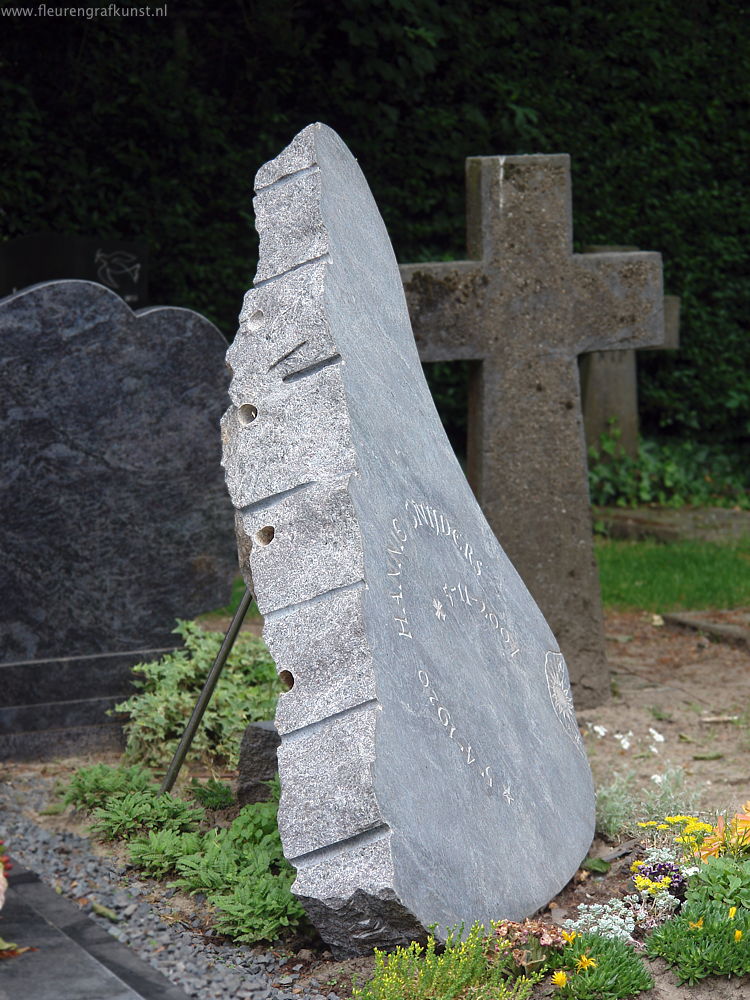 Natuursteenmuziek- (de open klep van-) een grote vleugel in graniet als grafsteen (Oisterwijk, N.Br.)