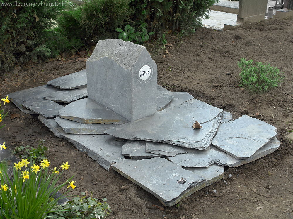 Grafhuisje van Ierse hardsteen met de naam op fotoporselein en grijs-zwarte leisteen op de grond als bodembedekking