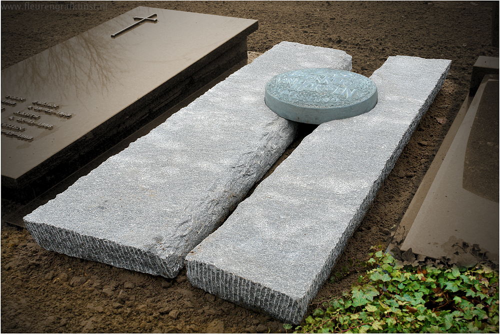 Twee grafstenen ineen: naampenning ingelegd op compositie van gesplitste ruwe graniet (Eindhoven-Helmond-Asten)