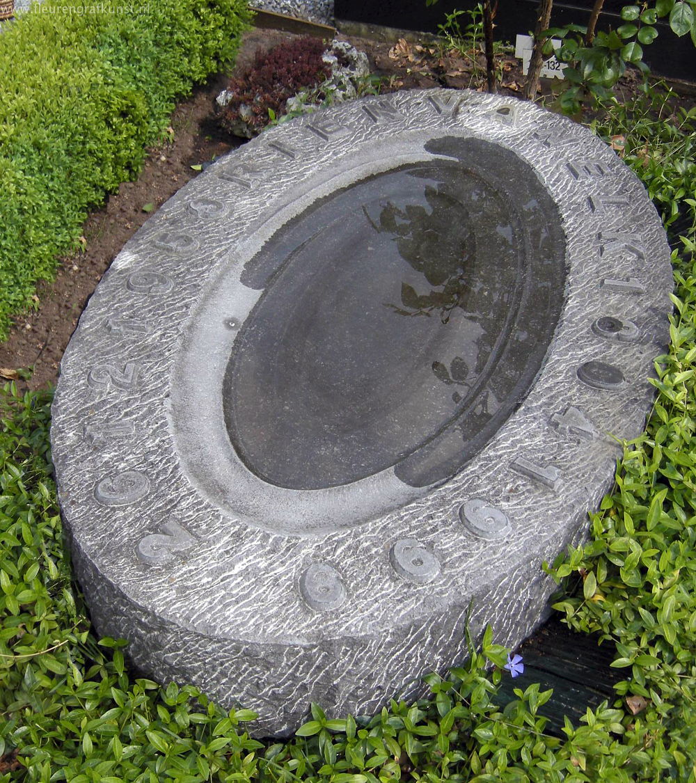 Grote ovalen grafsteen met water voor de vogels in Rosmalen