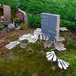 Monument met rvs-bladeren van een gatenplant voor een overleden kweker