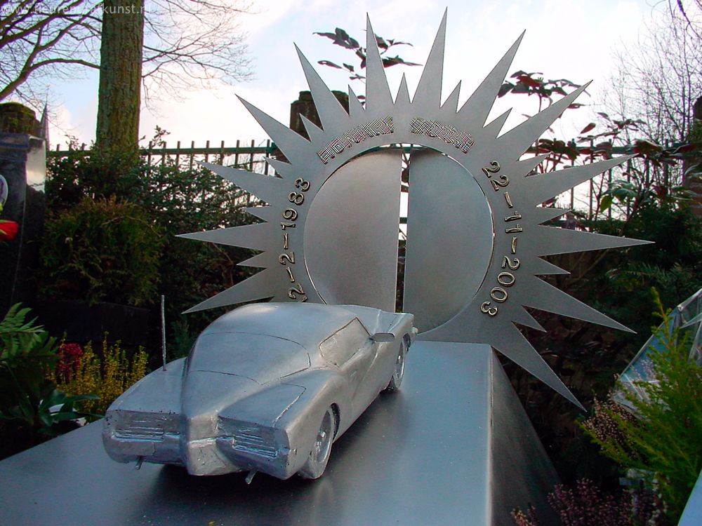 Een tragische grafsteen van roestvrijstaal / roestvaststaal: een gegoten aluminium modelauto scheurt richting hemelpoort