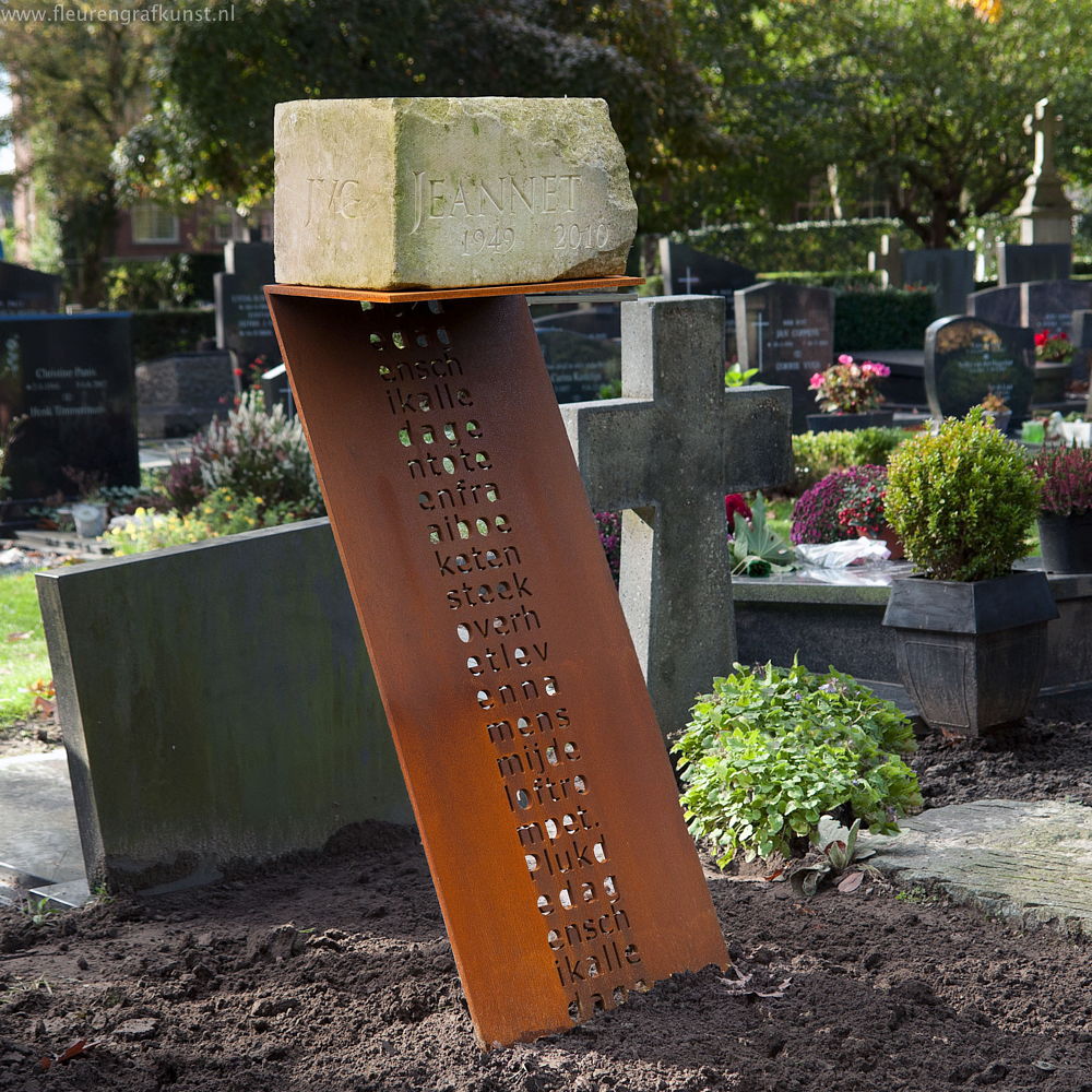 Franse kalksteen als grafsteen staat op een sokkel van cortenstaal met een uitgesneden gedicht - de open letters zijn uit staal gesneden met een waterjet