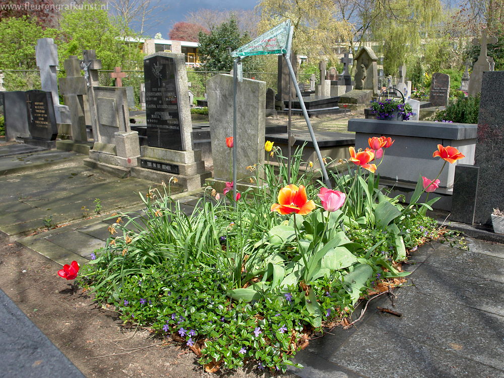 Prachtig bloemengraf in Tilburg van minimalistisch glas gemonteerd op een ijl frame van gegalvaniseerd ijzer