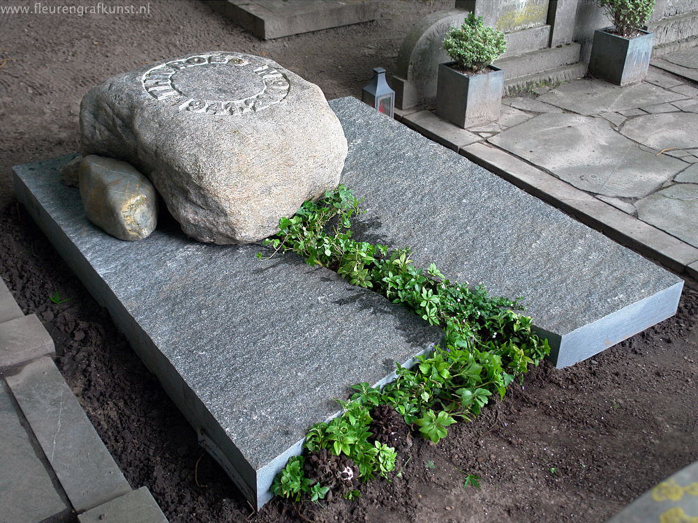 Grote zwerfsteen als grafmonument op ruwe graniet - in de zwerfkei zijn de uitgekapte letters en cijfers goed te zien