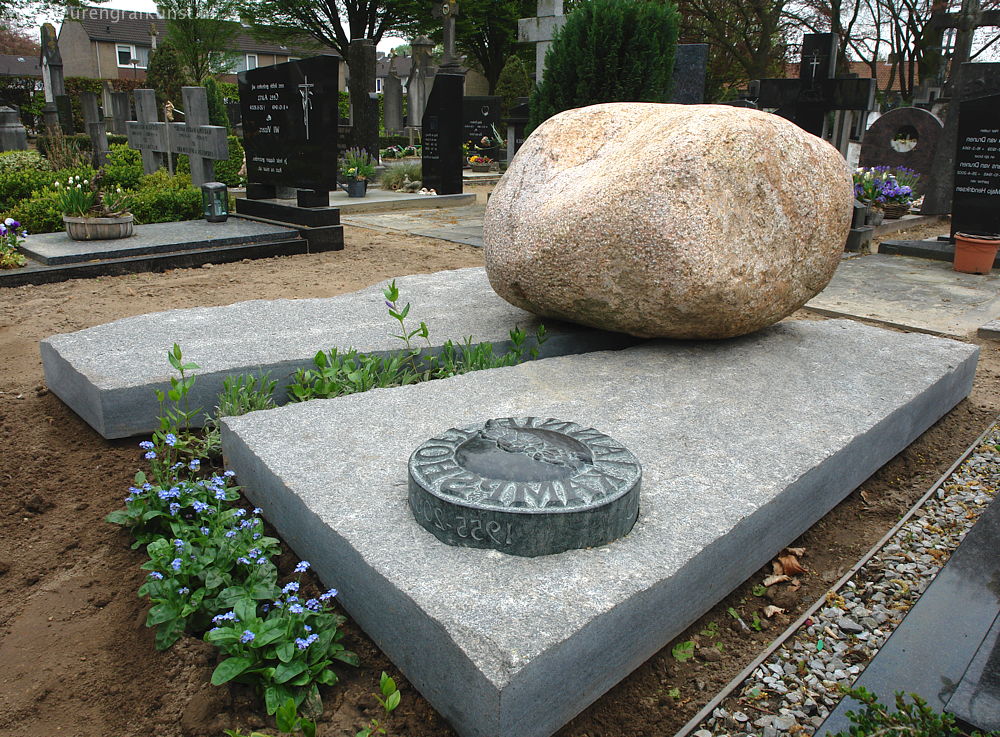 Dubbel graf van ruwe graniet met grote zwerfsteen en naam-penning van bewerkte diabas in Berkel-Enschot