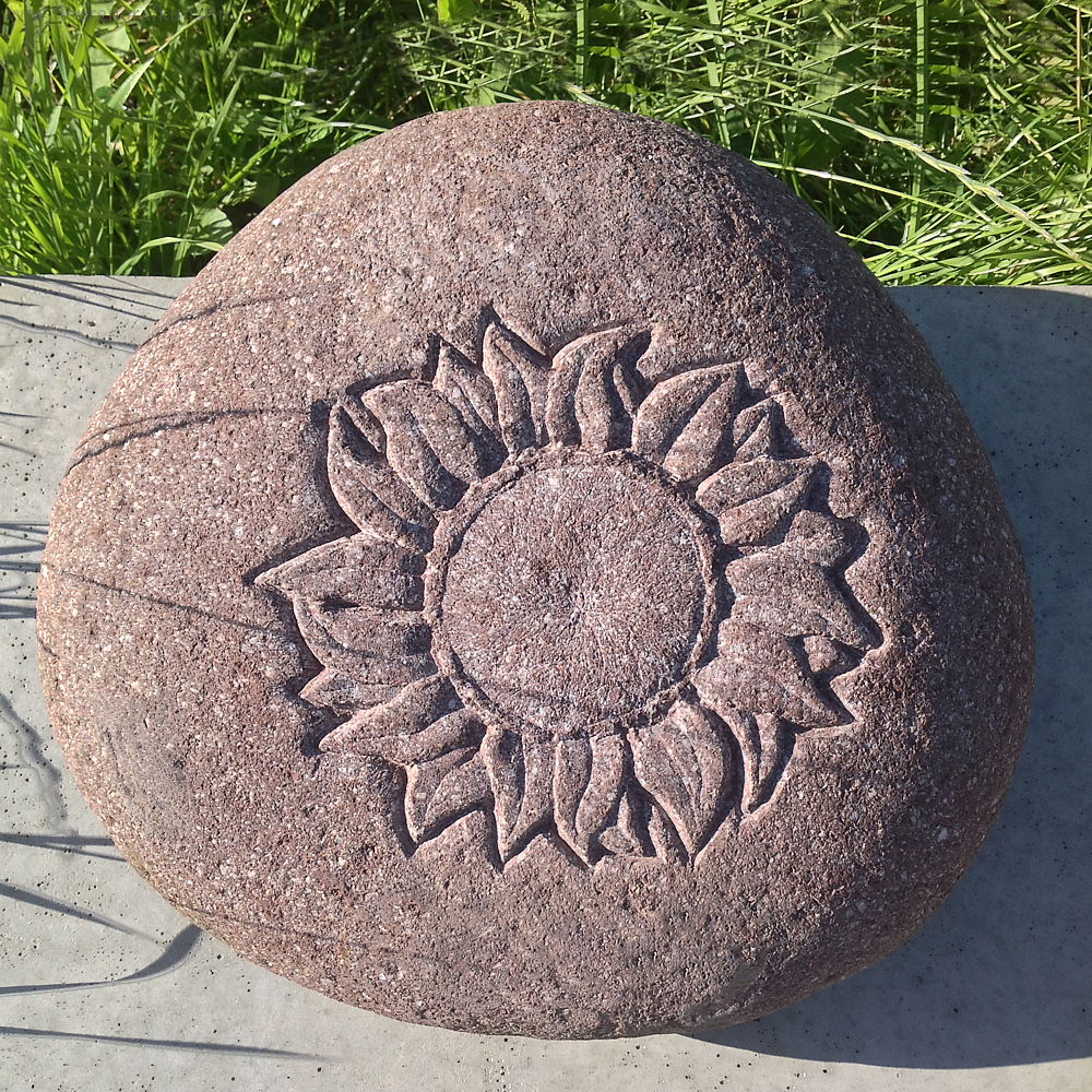 Zwerfsteen met afbeelding van een zonnebloem in relief gehakt